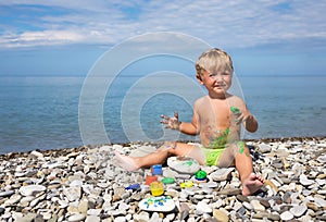 Kid soiled by paints on beach