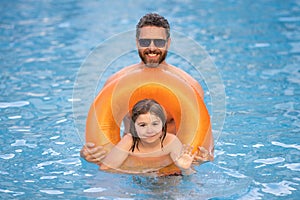 Kid splash water in pool. Father and son swimming and splashing in blue sea water. Family on summer holiday. Happy