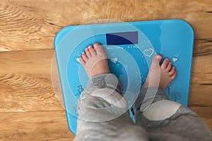 Kid standing on electronic scale barefoot