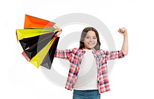 Kid strong makes independent purchases. Girl carries shopping bags isolated on white background. Girl fond of shopping