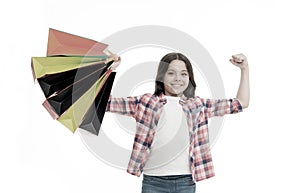 Kid strong makes independent purchases. Girl carries shopping bags isolated on white background. Girl fond of shopping