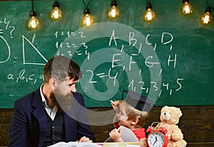 Kid studies individually with teacher, at home. Individual schooling concept. Father with beard, teacher teaches son