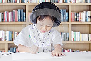 Kid studying in library while wearing headset