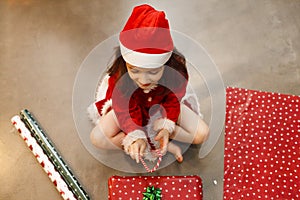 Kid surrounded with christmas presents at home