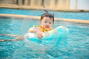 Kid swim in the swimming pool on summer holiday. Asian little girl lifestyle