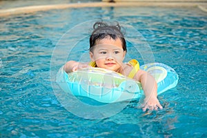 Kid swim in the swimming pool on summer holiday. Asian little girl lifestyle