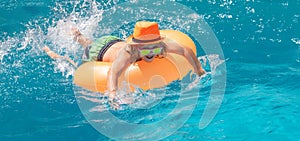 Kid swim in swimming pool. Water sport activity on summer vacation with children. Summer travelling.