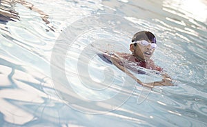 A Kid swimming with head outside the water