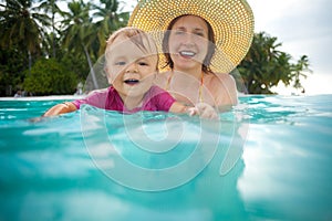 Kid swimming with mothers help