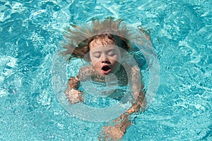 Kid in swimming pool. Boy Practice Swimming.