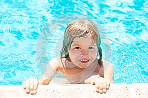 Kid in swimming pool. Little boy playing in outdoor swimming pool in water on summer vacation. Child learning to swim in