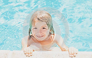 Kid in swimming pool. Little boy playing in outdoor swimming pool in water on summer vacation. Child learning to swim in