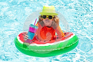 Kid in swimming pool, relax swim on inflatable ring and has fun in water on summer vacation. Kids summer vacation