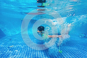 Kid swimming underwater in pool