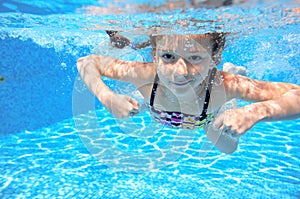 Kid swims in pool underwater, girl swimming