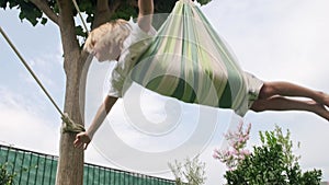 Kid swinging on hammock.