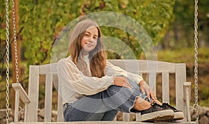 kid swinging outdoor. teen girl having fun on playground. childhood happiness. relax in park.