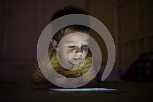 Kid with tablet in the dark