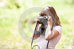 Kid thoughtful girl with a camera, spring and childhood