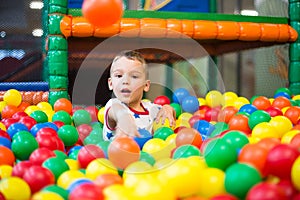 Kid throwing colorful plastic ball towards camera