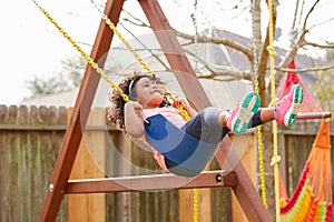 Kid toddler girl swinging on a playground swing