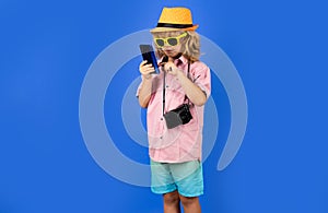 Kid tourist blogger making photo for social networks on phone. Travel with kids, tourism.