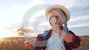 Kid tourist examines the plant with a magnifying glass. travel tourism adventure concept. little kid boyscout girl with