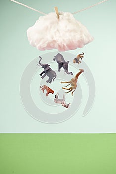 Kid toy animals raining from a cloud clipped on a rope