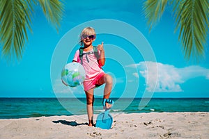 Kid travel on beach, cute girl with backpack and globe on vacation