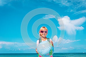 Kid travel on beach, little girl with globe at sea