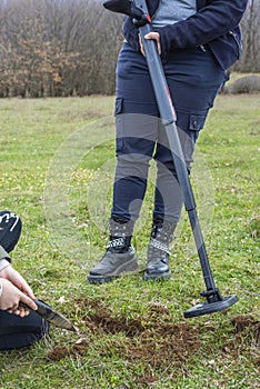 Kid treasure hunters metal detecting and digging the ground