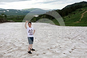 Kid trekking through snowfield of Lago-Naki plateau