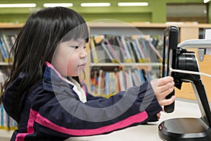 Kid using digital tablet in library