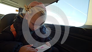 Kid using phone to draw during the car trip