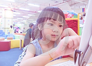 Kid using tablet in classroom, focusing on the hand and tablet