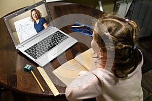 Kid virtual learning with teacher by laptop, tutor teaches preschool child during quarantine due to coronavirus