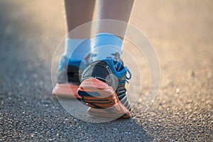 Kid walking, exercising on a rural road, close up on kids feet wearing gym shoes