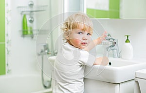 Kid washing hands in bathroom