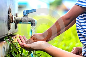 Kid washing hands with mother, selective focus point.