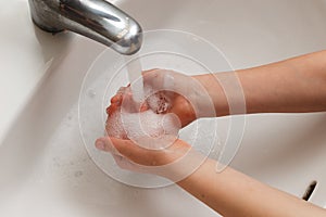 Kid washing hands rubbing soap during CoronaVirus pandemic episode