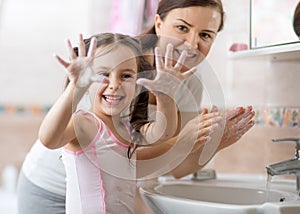 Kid washing hands and showing soapy palms