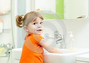 Kid washing hands and showing soapy palms