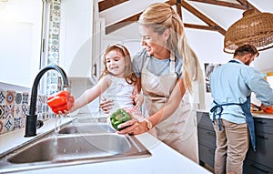 Kid, washing vegetables and cooking with mother together with healthy food, nutrition and and diet for lunch, dinner and