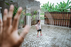 Kid waving goodbye before leaving to school