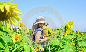 Kid wear straw summer hat. child in field of yellow flowers. teen girl in sunflower field. concept of summer vacation