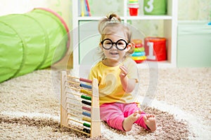 Kid weared eyeglasses playing with abacus photo