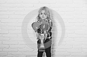 Kid wearing boxing glove, boy boxer winning golden champion cup