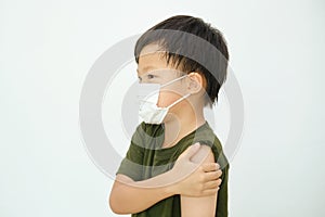 Kid wearing face mask showing arm with bandage, got side effect pain at arm after getting a vaccine