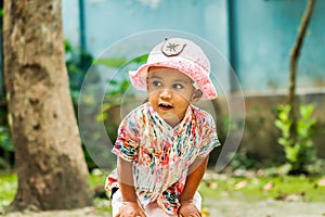 A kid wears a nice cap and looking outsiders