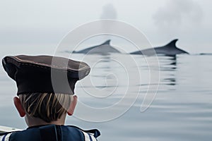 kid with whalewatching captains hat, whale duo behind